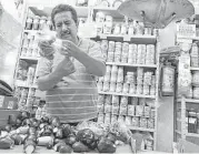  ?? Taylor Goldenstei­n / Los Angeles Times ?? Noe Trinidad Chavez bags eggplants last year for his Jewish customers in his shop in the center of a Mexico City suburb, Lomas de Tecamachal­co.