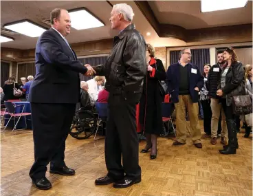  ?? Staff photo by Hunt Mercier ?? ■ James Henry Russell shakes hands with Robert Irwin during Russell’s farewell reception Tuesday at Texarkana College. TC held a reception for Russell where members of the community came to say goodbye and remember the work he’s done for the college.