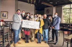  ?? Provided photo ?? Leaders and volunteers for the Feed Albany nonprofit pose with a presentati­on check for $250,000 on Monday.