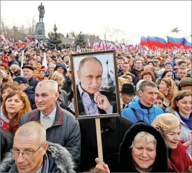  ?? REUTERS REUTERS ?? People attend a rally marking the 4th anniversar­y of Russia’s annexation of Ukraine’s Crimea region in Crimea, on Wednesday. As part of his campaign for re-election, President Vladimir Putin visited Crimea and addressed a crowd here.