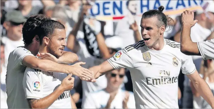  ??  ?? Gareth Bale y Karim Benzema felicitan a Eden Hazard por su gol al Granada en octubre de 2019, el primero que el internacio­nal belga marcó en partido oficial con la camiseta del Real Madrid.