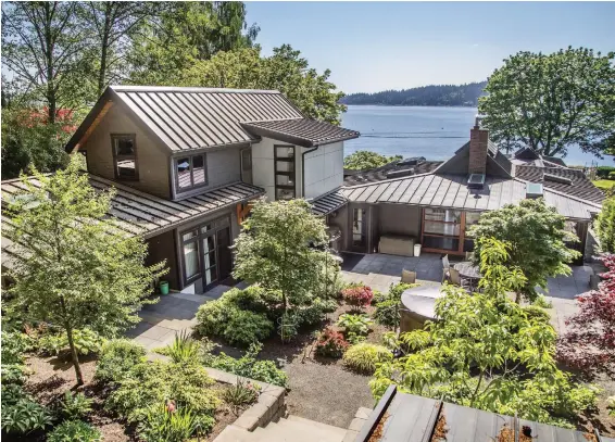  ??  ?? The renovated home overlooks the water and features a central courtyard in the private backyard that has no water view, but the forest view is just as important, says the architect.