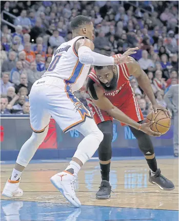  ??  ?? Houston guard James Harden, right, is defended by Oklahoma’s Russell Westbrook.