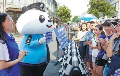  ?? GAO ERQIANG / CHINA DAILY ?? Shen Yijie, a junior at Zhejiang Police College, wears a cartoon panda costume while providing assistance to tourists lined up at the security check for admission to Hangzhou’s West Lake. The city has beefed up security ahead of the G20 summit.