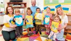  ?? ?? Rev David Downing and Jolanta Pietrusins­ka, right, with Natalia Zarivna, a Ukrainian refugee, and children from Patchwork Day Nursery, holding their pictures which will be sent with donations. Ref: 134499-3
