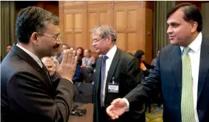  ??  ?? Deepak Mittal, joint secretary of India’s Ministry of External Affairs (left), greets Pakistan’s Syed Faraz Hussain Zaidi as they wait for judges to enter the World Court in The Hague, Netherland­s, on Monday. — AP