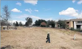  ??  ?? SETH SLOCUM of Costa Mesa walks on the site of the former homeless camp. The cleanup figures reflect work from Jan. 22 to March 3 along two miles of trail.