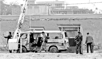  ??  ?? Afghan security forces inspect the site of a suicide attack in Kabul, Afghanista­n. — Reuters photo