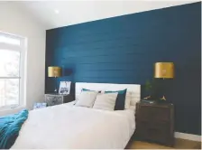  ??  ?? A feature wall in one of the bedrooms is given dramatic flair with its shiplap for texture and a modern pop of colour with teal.