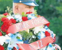  ??  ?? Fire Department Dive Master David Evans places a wreath during a 9/11 memorial service at the Gary City Hall on Saturday.