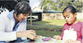  ??  ?? St Catherine’s Principal Vanessa Janse van Rensburg assists Agheeda Adams with her name bracelet