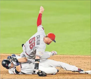  ?? Hannah Foslien Getty Images ?? KOLE CALHOUN of the Angels trips over the Twins’ Max Kepler, who is safe at second base after a sixthinnin­g hit. Kepler was a notable Angels tormentor, with four hits including a homer, and three RBIs.