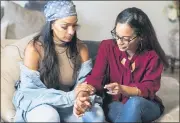  ?? MARY ALTAFFER — THE ASSOCIATED PRESS ?? Katherine, left, and Jennifer Guzman hold hands while talking about their mother Lunisol Guzman and life after her death from symptoms COVID-19, Sept. 17, in Newark, N.J.