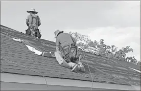  ?? John Bailey ?? Workers tack down shingles on the roofs of the complex near the Summervill­e Park neighborho­od early Wednesday before temperatur­es began reaching into the mid 90s.