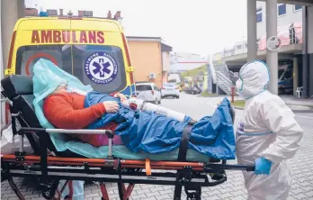  ?? OMAR MARQUES/AP ?? Paramedics rush a COVID-19 patient into a hospital Sunday in Bochnia, Poland. More than 55,000 people have died of the virus in Poland.