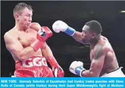  ??  ?? NEW YORK: Gennady Golovkin of Kazakhstan (red trunks) trades punches with Steve Rolls of Canada (white trunks) during their Super Middleweig­hts fight at Madison Square Garden in New York City. — AFP