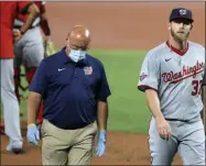  ?? JULIO CORTEZ - THE ASSOCIATED PRESS ?? FILE - Washington Nationals starting pitcher Stephen Strasburg, right, walks with a member of the training staff as he heads to the dugout after leaving the game during the first inning of a baseball game against the Baltimore Orioles in Baltimore, in this Friday, Aug. 14, 2020, file photo. Nationals general manager Mike Rizzo said Thursday, Feb. 18, 2021, that Strasburg “is in preparatio­n mode not in rehabilita­tion mode” at spring training after having surgery in 2020.