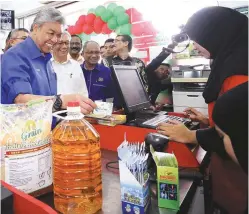  ??  ?? Ahmad Zahid making a purchase after opening the outlet.