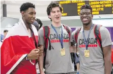  ??  ?? Team Canada players, from left, R.J. Barrett, Danilo Djuricic and Amidou Bamba, celebrate with fans after arriving at Toronto’s Pearson Airport on Monday.