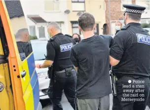  ??  ?? ● Police lead a man away after the raid on Merseyside