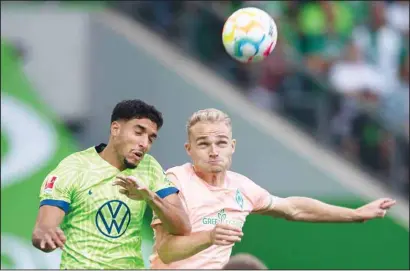  ?? ?? Wolfsburg’s Omar Marmoush, (left), and Bremen’s Amos Pieper challenge for the ball during the German Bundesliga soccer match between Vfl Wolfsburg and SV Werder Bremen in Wolfsburg, Germany. (AP)