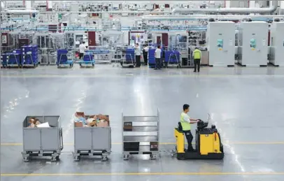  ?? LI BO / XINHUA ?? Employees of a foreign auto-parts maker work at a production facility in Taicang, Jiangsu province.