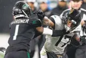  ?? SETH WENIG AP ?? Jaguars tight end Evan Engram stiff-arms Jets cornerback Sauce Gardner during the third quarter.