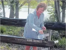  ?? BERND FRANKE
THE ST. CATHARINES STANDARD ?? Robin Hilmayer christens a double in memory of Debbie Skerrett Hepburn during a ceremony at Niagara Falls Rowing Club.