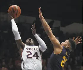  ?? Ben Margot / Associated Press ?? St. Mary’s Malik Fitts shoots over Cal’s Matt Bradley in the first half on his way to 19 points in a game in which the Gaels’ three-pointers buried the Bears.