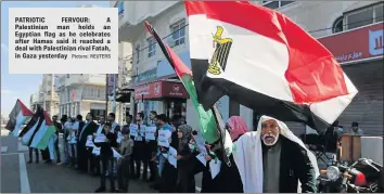  ?? Picture: REUTERS ?? PATRIOTIC FERVOUR: A Palestinia­n man holds an Egyptian flag as he celebrates after Hamas said it reached a deal with Palestinia­n rival Fatah, in Gaza yesterday