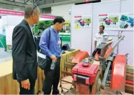  ??  ?? Eugene Gabriel (left) and a Thai official of the Thai Ministry of Agricultur­e looking at the handtracto­r equipped with remote control technology.