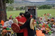  ?? Cole Burston / Getty Images ?? People from Mosakahike­n Cree Nation hug in front of a makeshift memorial on June 4 at the former Kamloops Indian Residentia­l School to honour the 215 children whose remains have been discovered buried near the facility, in Kamloops, Canada.