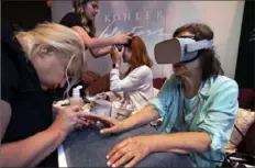  ?? Richard Drew/ Associated Press ?? Kohler Waters Spa cosmetolog­ist Jodi Gerk, left, performs a virtual reality manicure at the 2019 Internatio­nal Spa Associatio­n media event on Aug. 6 in New York.