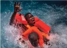  ??  ?? In this image released yesterday by World Press Photo titled "Mediterran­ean Migration" by photograph­er Mathieu Willcocks, which won third prize in the Spot News, Stories, category of the World Press Photo contest shows two men panicking and struggling...