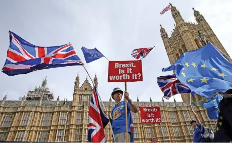  ?? (AFP) ?? A demonstrat­or holds a sign outside the Houses of Parliament in central London on September 10