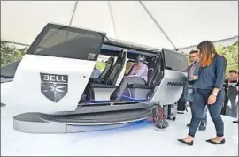 ?? Robyn Beck AFP/Getty Images ?? DURING THE Uber Elevate Summit last May in Los Angeles, an attendee wearing virtual reality glasses sits in a model of Bell Helicopter’s air taxi cabin concept.