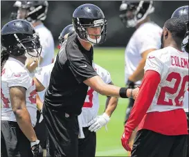  ??  ?? Quarterbac­k Matt Ryan greets Freeman (left) and Coleman during minicamp in June. The players on offense are largely unchanged from the group that led the NFL in scoring last season. Ryan set franchise records in passing yards (4,944) and touchdowns (38).