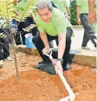  ??  ?? HIJAUKAN BUMI: Awang Tengah menanam pokok sempena sambutan Hari Hutan Antarabang­sa Peringkat Negeri Sarawak 2015 di Kuching semalam.