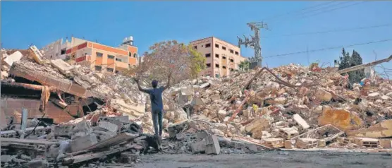  ?? AFP ?? A Palestinia­n man gestures in despair as he stands at the site of a building destroyed by Israeli air raids in Gaza City on Tuesday.