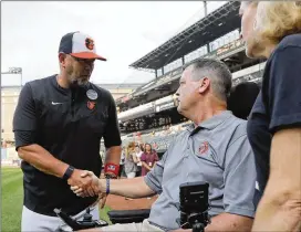  ?? JULIO CORTEZ/AP ?? Orioles manager Brandon Hyde (left) talks with former Orioles pitcher Jim Poole, who has ALS, and his wife, Kim Poole, during Lou Gehrig Day on Thursday.