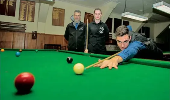  ?? Photo / Ian Cooper ?? Sam Martin lines up a shot as manager Dave Judd (left) and teammate Michaela Spencer look on in the build-up to the world under-21 and under-18 championsh­ips in China.