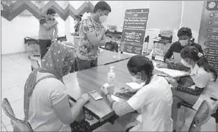  ??  ?? AHMEDABAD
People get their names registered after receiving a dose of COVISHIELD, a coronaviru­s disease (COVID-19) vaccine manufactur­ed by Serum Institute of India, at a vaccinatio­n centre in Ahmedabad, India. -AP