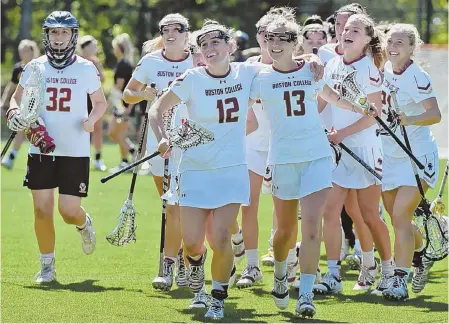  ?? STAFF PHOTO BY PATRICK WHITTEMORE ?? MOVING ON: The players of the Boston College women’s lacrosse team run off the field all smiles after their victory against Southern Cal yesterday in Newton. The Eagles advanced to the NCAA final four at Gillette Stadium.