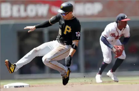  ?? Associated Press ?? Bryan Reynolds advances to second base as the Braves’ Ozzie Albies fields a ground ball from Starling Marte.