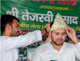  ?? — PTI ?? RJD leaders Tej Pratap crowns his brother Tejashwi Yadav during the 22nd Foundation Day of the Rashtriya Janata Dal in Patna on Thursday.