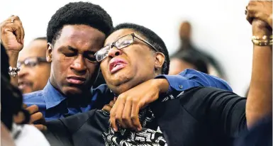  ?? AP ?? Allison Jean raises her hands in the air as she leans on her son, Grant, 15, during a prayer service for her son and Grant’s brother Botham Jean at the Dallas West Church of Christ on Sunday, September 9, 2018 in Dallas. Botham Jean was shot and killed by Dallas police officer Amber Guyger in his apartment on Thursday night.