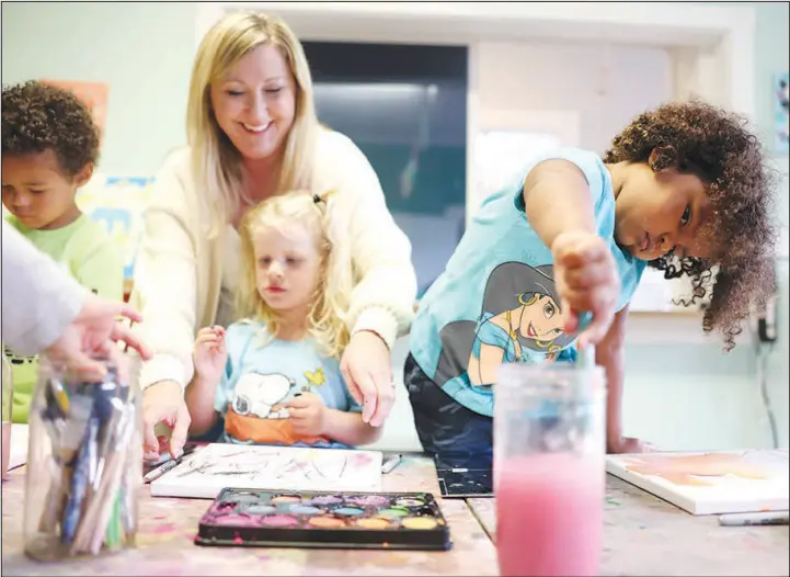  ?? CRAIG MITCHELLDY­ER / ASSOCIATED PRESS (2022) ?? Winnie Vandusen, 3, right, paints at the Bumble Art Studio day care center, while the center director Amy Atkinson helps another child Sept. 2 in Astoria, Ore. To ease a persistent chid care crunch, states are turning to a variety of ideas including grants, tax credits, salary supplement­s and incentives.