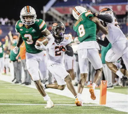  ?? AL DIAZ adiaz@miamiheral­d.com ?? Hurricanes wide receiver Mike Harley scores in the fourth quarter to bring the Hurricanes to within three points of Oklahoma State. But the rally ended there as UM lost in the Cheez-It Bowl on Tuesday in Orlando.