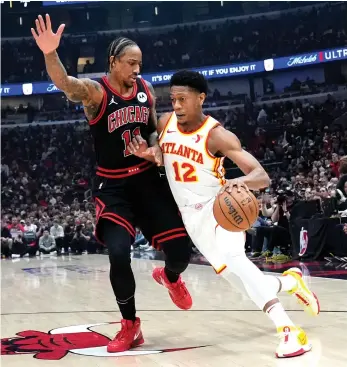  ?? NAM Y. HUH/AP ?? Bulls forward DeMar DeRozan, who was honored for his community work in mental health before the game, tries to prevent Hawks forward De’Andre Hunter from driving to the basket Wednesday.