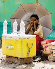  ?? Photos: Reuters, EPA ?? A girl selling water uses an umbrella to protect herself from the sun in New Delhi, while in Kolkata (below) a worker covers up as he takes a break, and another cools off in the back of a truck.